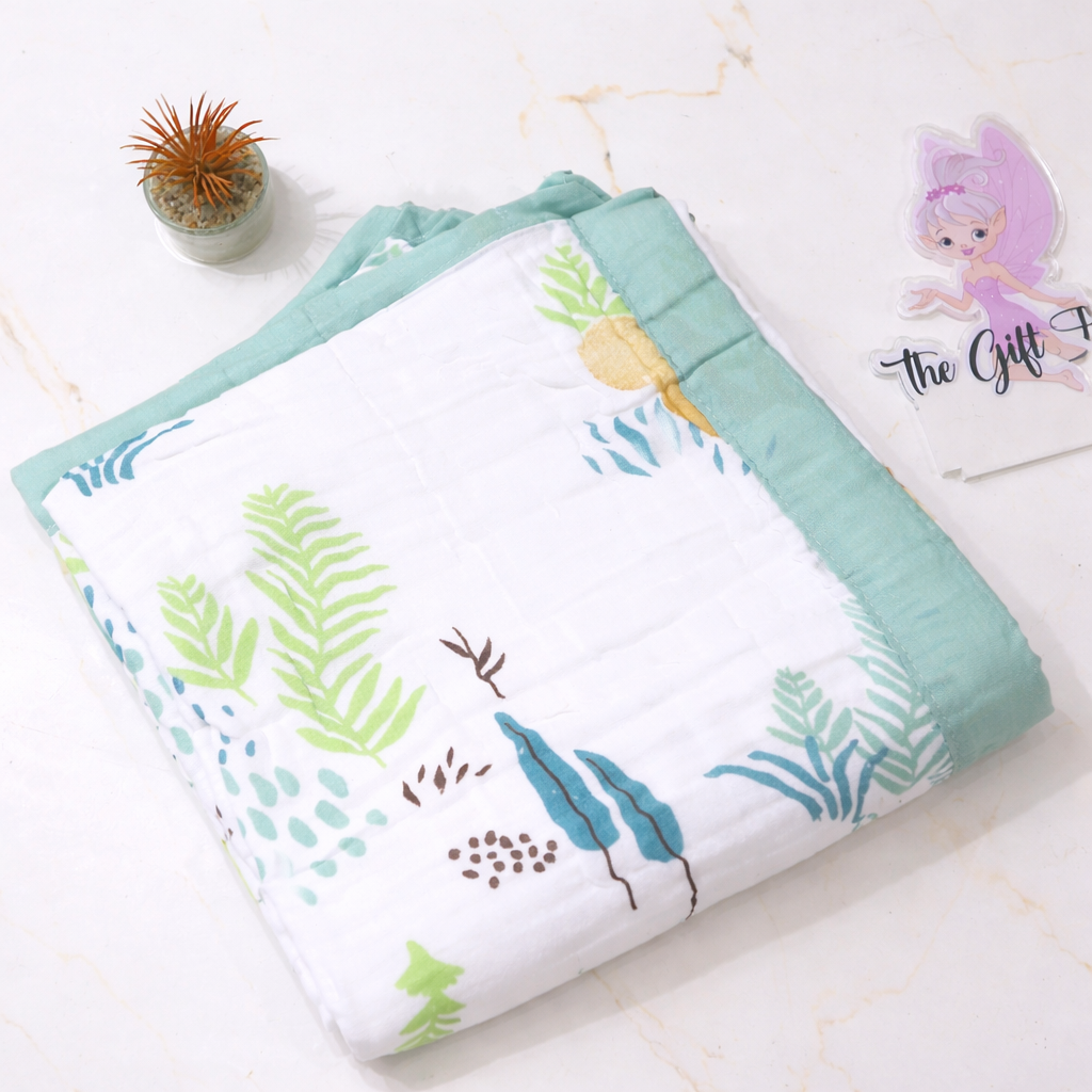 Folded baby blanket with leaf pattern on a white surface
