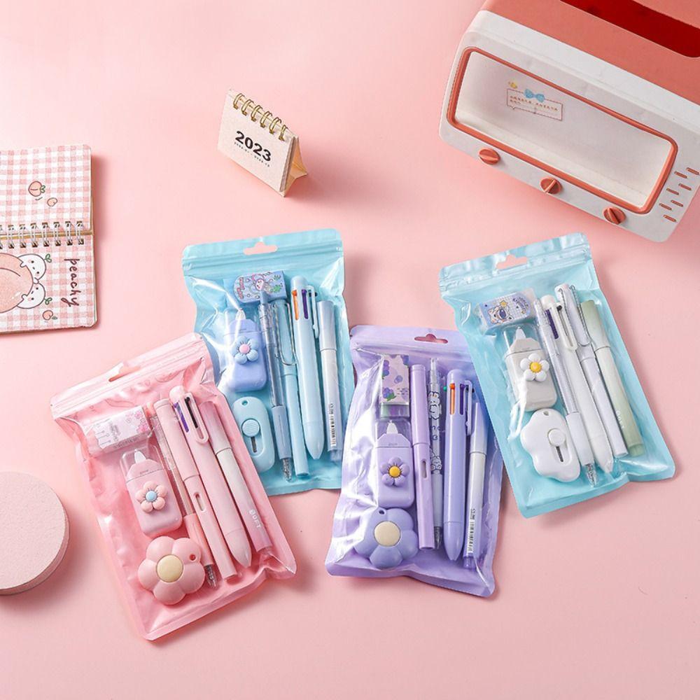Set of stationery items including pens, markers, and a small calendar on a pink background