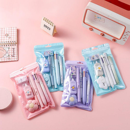 Set of stationery items including pens, markers, and a small calendar on a pink background