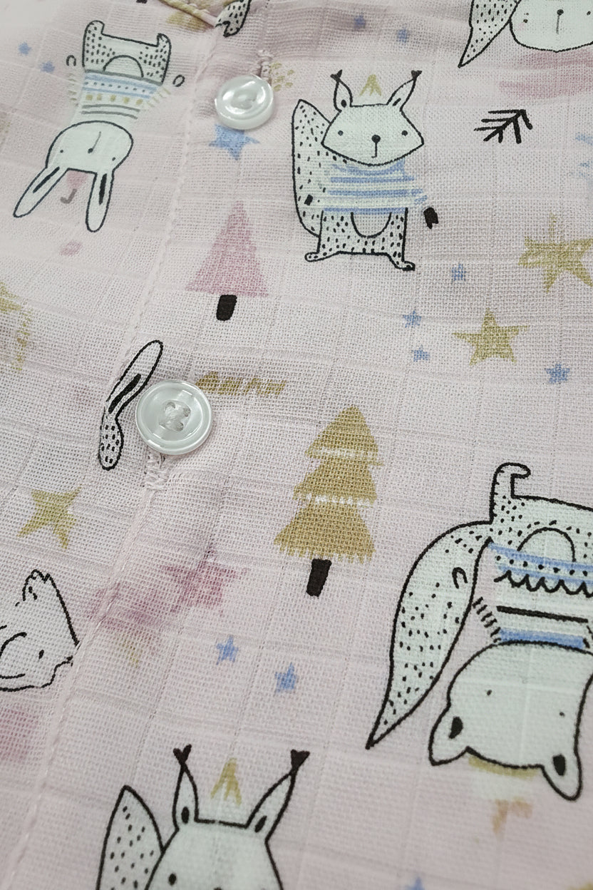 Fabric with cartoon animal designs and buttons on a pink background
